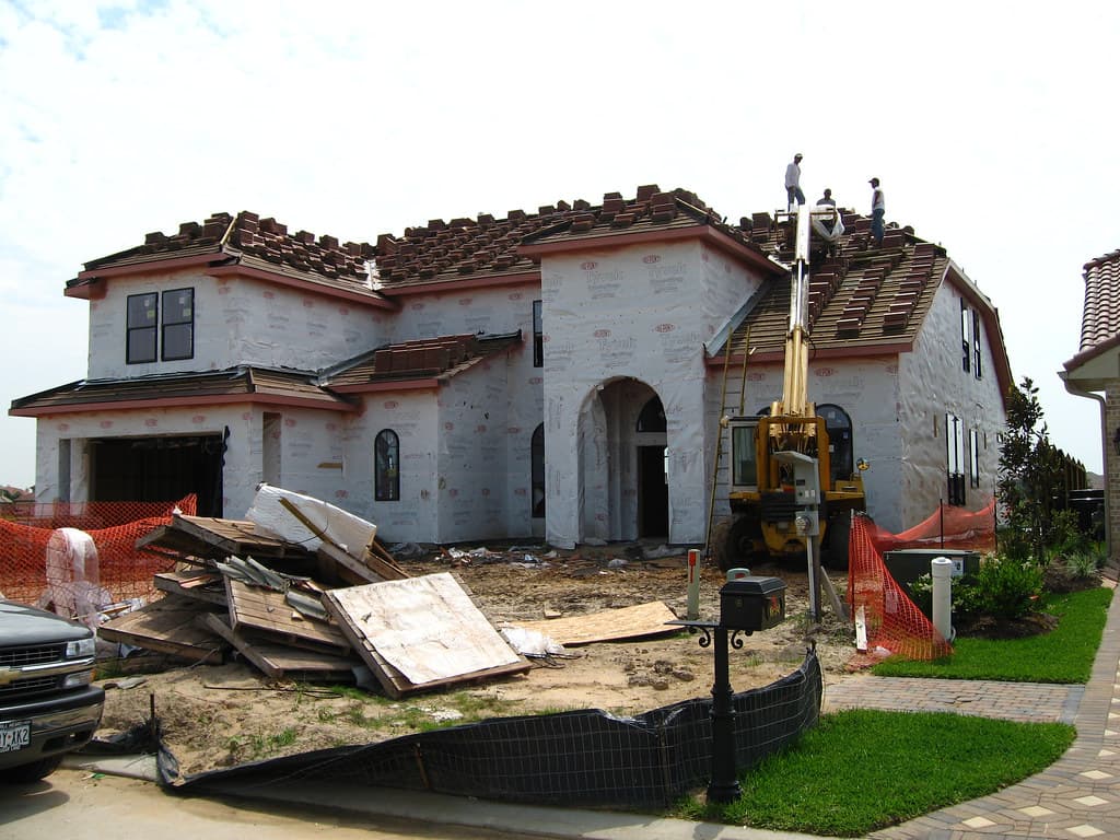 A roofing crew fixing sheets on a roof.